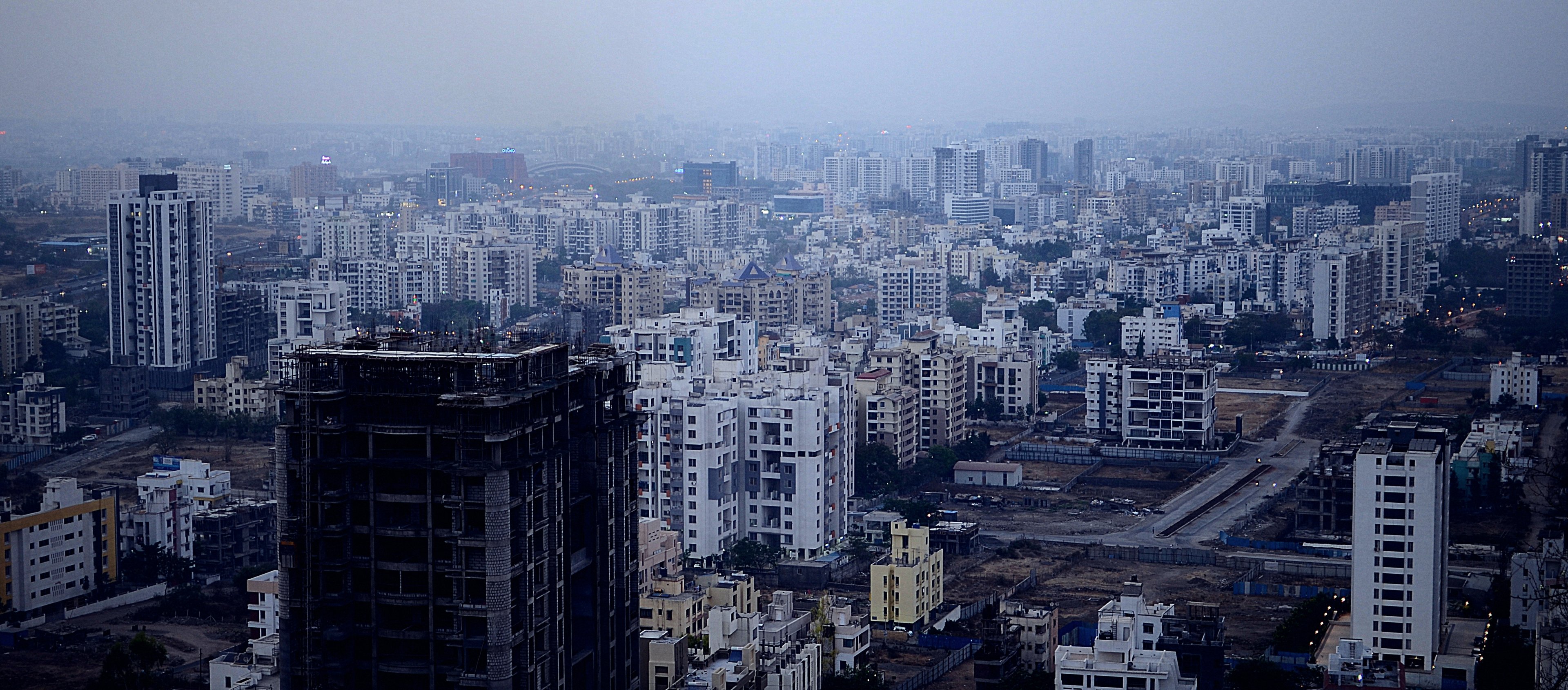 Pune west skyline in the evening haze, rows of residential towers to the horizon